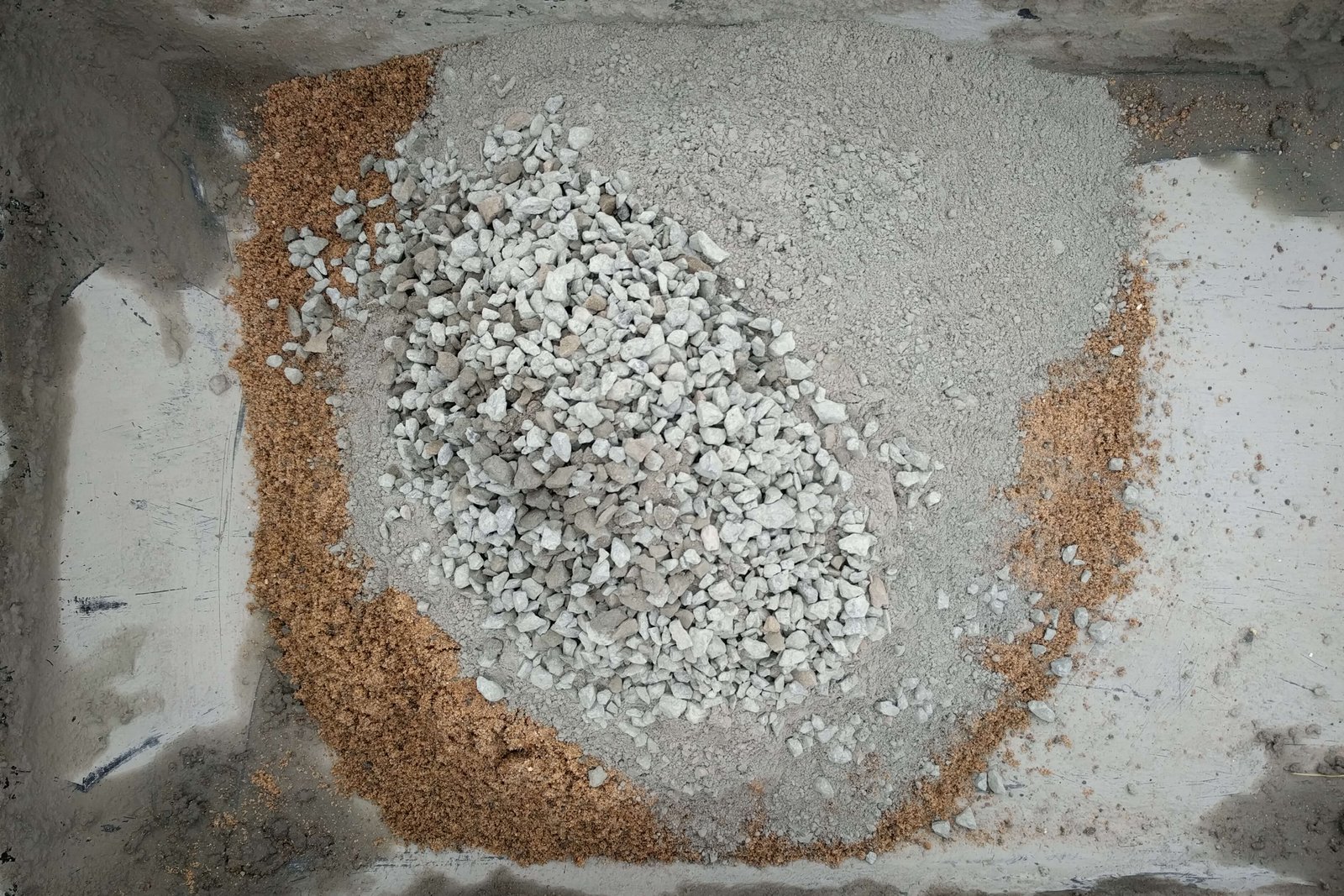 Glacial elsker sand, black volcanic basalt/dresser trap rock, portland cement in a black mixing tray
