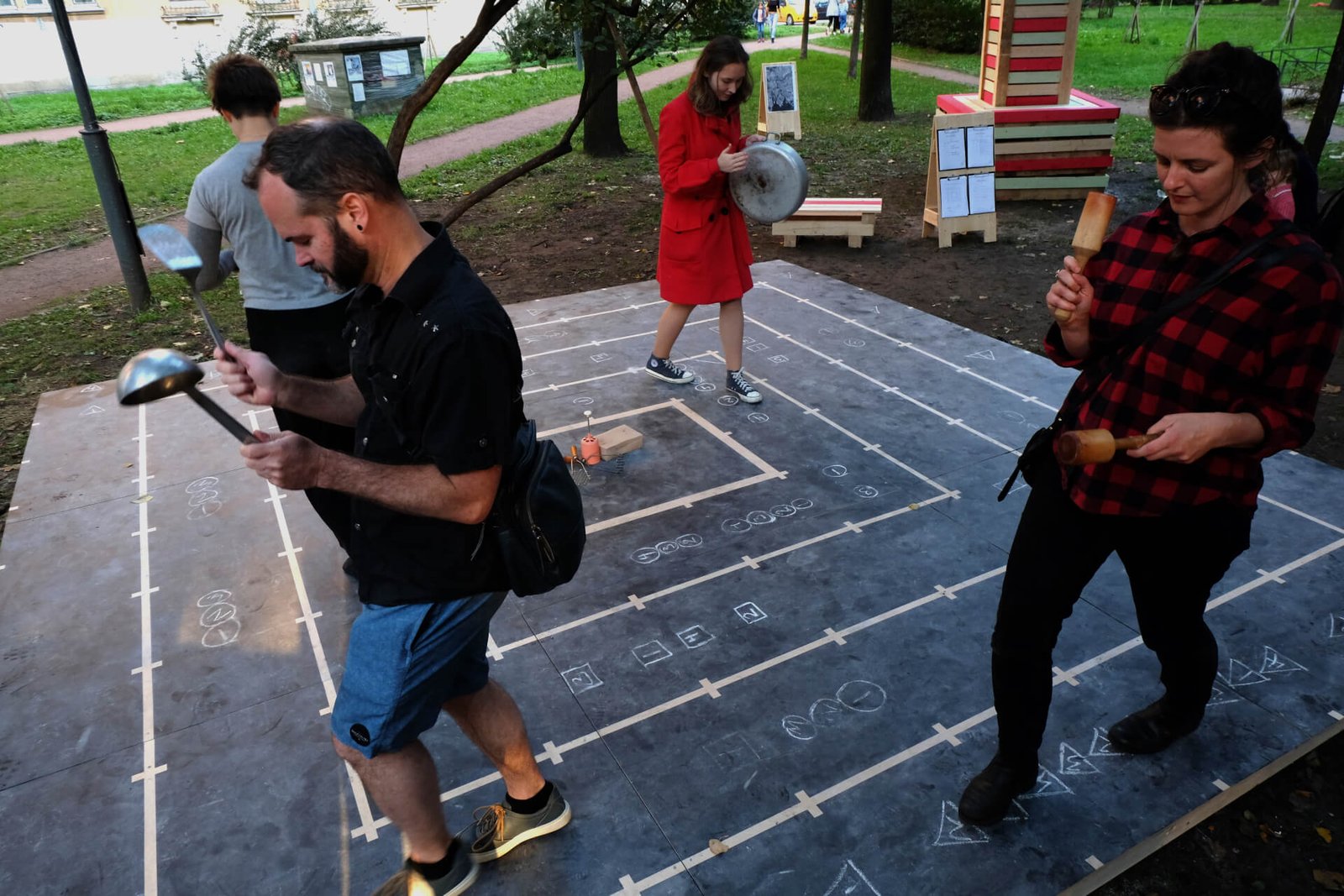 4 people playing kitchen tools as they walk on the 5 x 5 meter Tasty Score stage