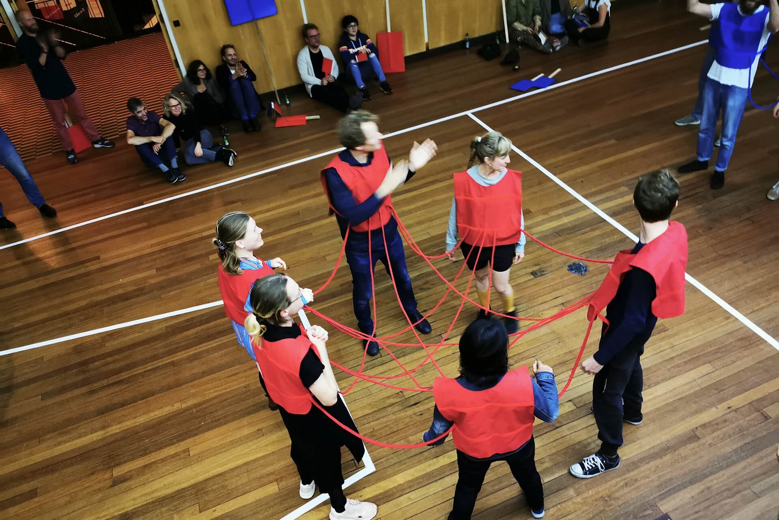 The Cauliflowers are six people all connected to each other by their red jerseys and connectors.