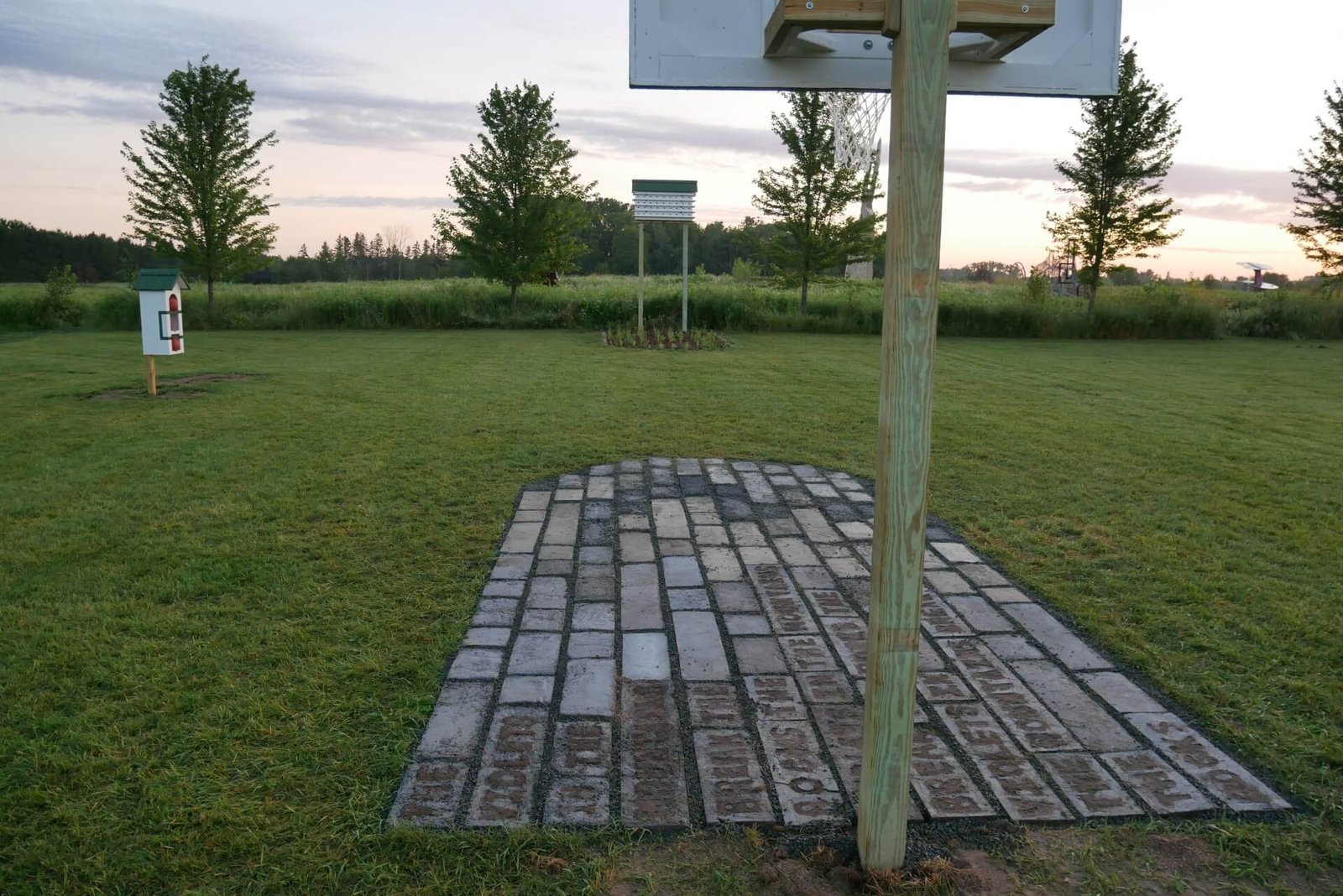 The Dirtball court is a concrete key with text and a basketball hoop, a garden key with a purple martin hotel and a small house for basketballs.