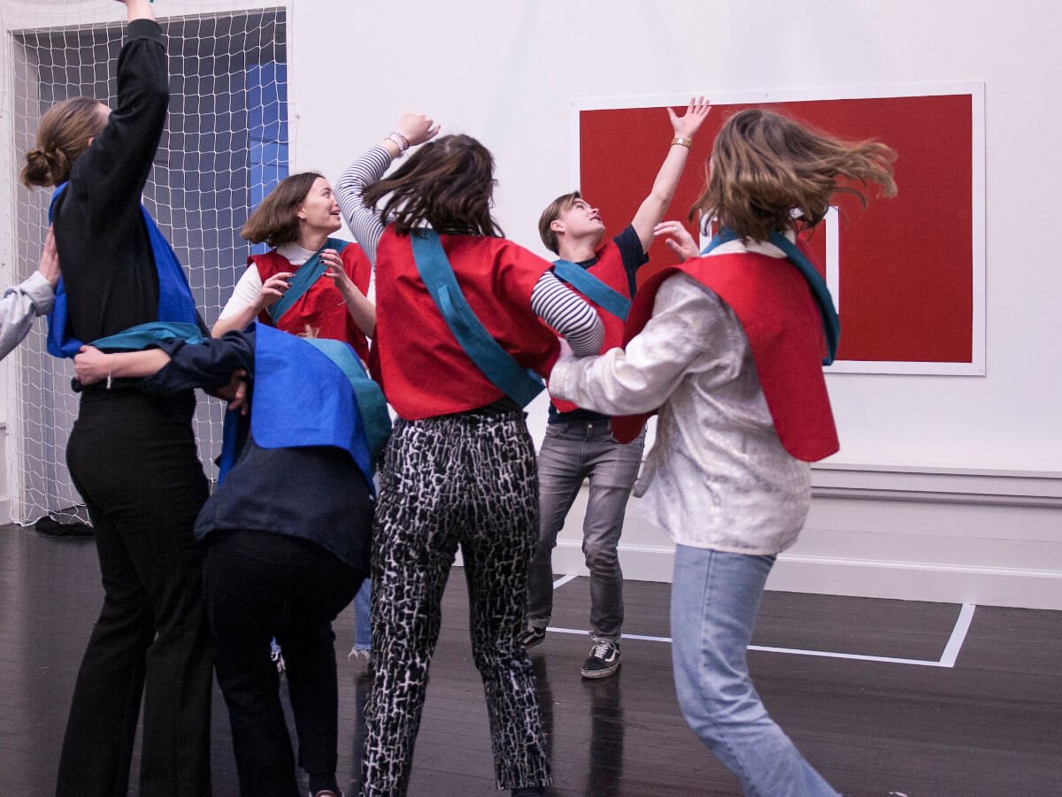 4 people in red jerseys and 2 in blue frantically playing freeze release