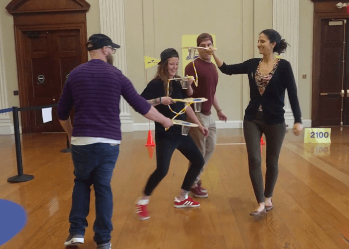 4 people holding their neighborhood paddles level as they turn in a circle