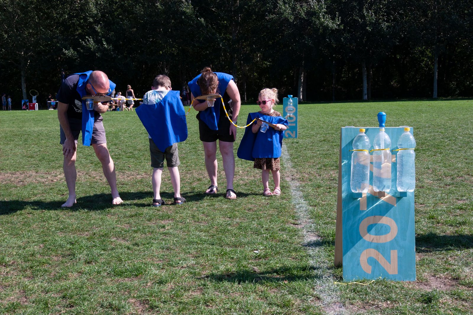 A family plays Long Dash. With paddles to noses three face forward and the fourth backwards